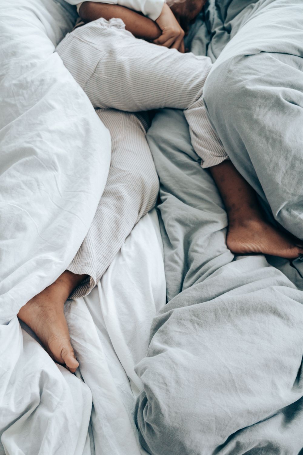 A tired person lying awake in bed in the early morning light